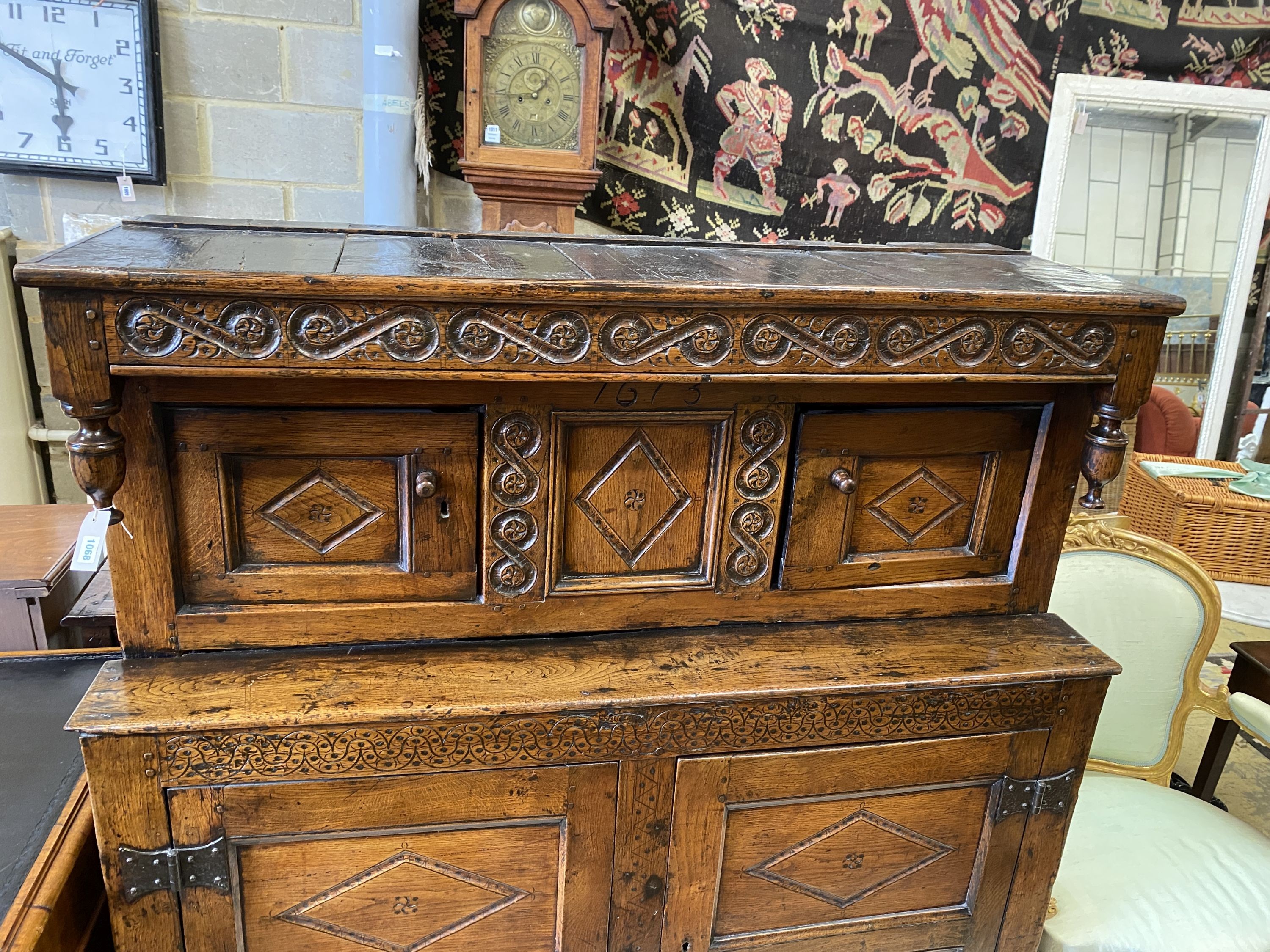 A Charles II oak court cupboard, dated 1673, width 140cm, depth 52cm, height 148cm